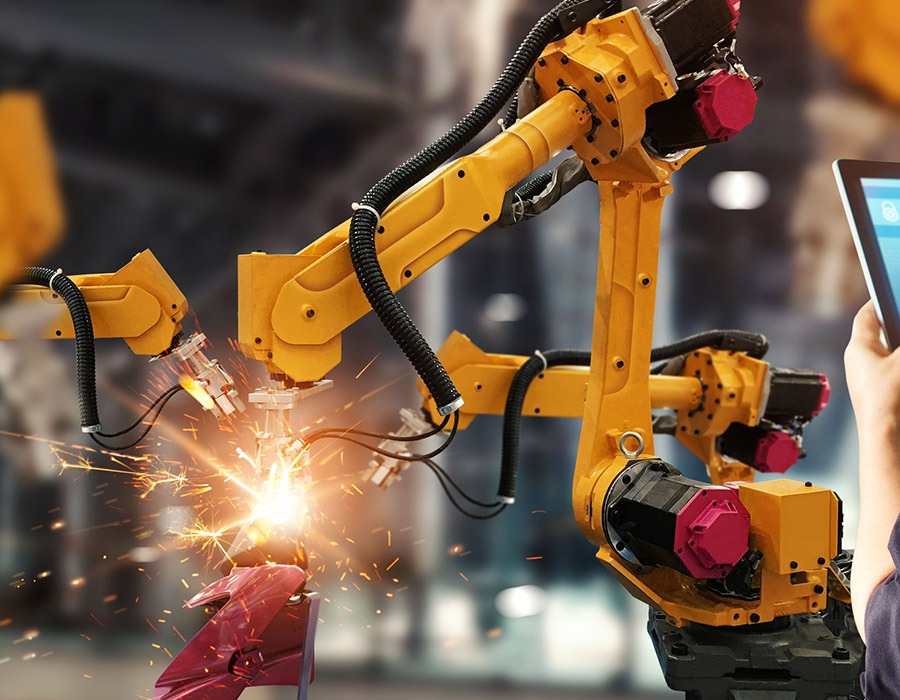 Robotic arms welding metal in a factory